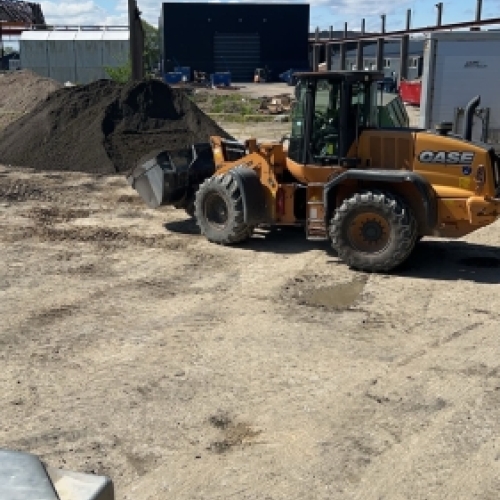 Læsning og bortkørsel af jord med gummiged på byggeplads